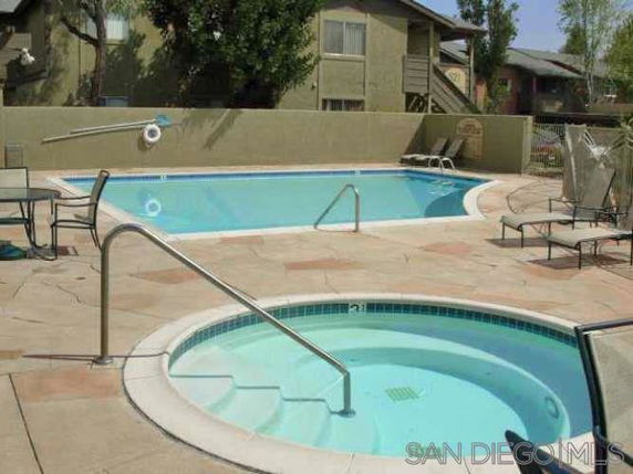 Outdoor swimming pool area with a main pool and a smaller circular pool.