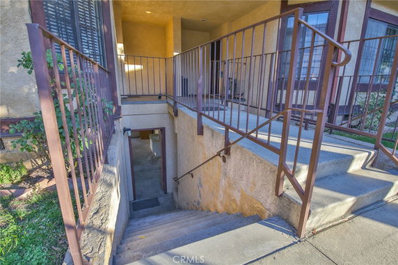 Side entrance with stairs leading to a lower level in a multi-story building.