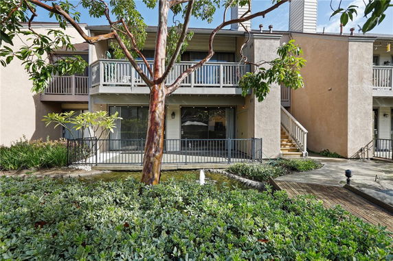 Front view of a residential building with balconies and a staircase.