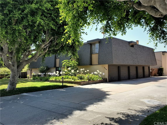 Front view of a two-story building with multiple garages and a shingled roof.