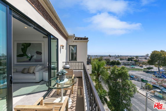 Balcony view from an apartment with surrounding cityscape.