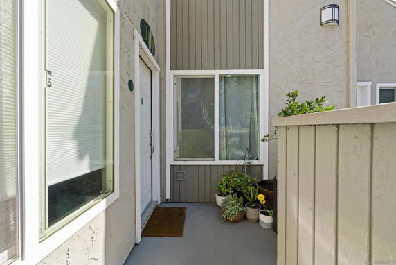Entrance view of a house with a white door and large windows.