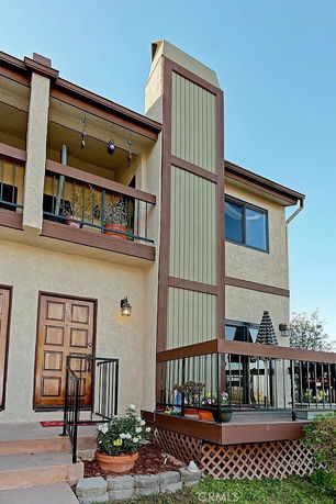 Front view of a two-story house with a balcony and chimney.