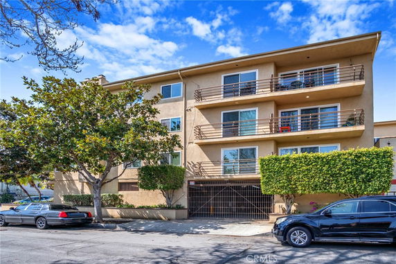 Front view of a multi-story apartment building with balconies.