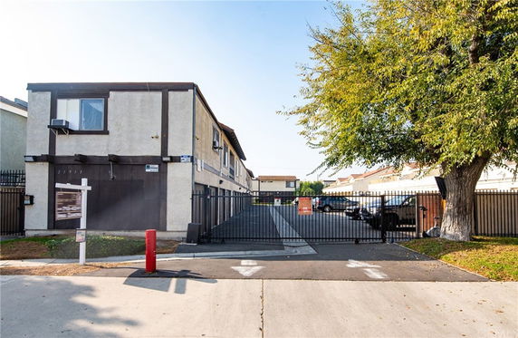Front view of a two-story building with a gated parking area.