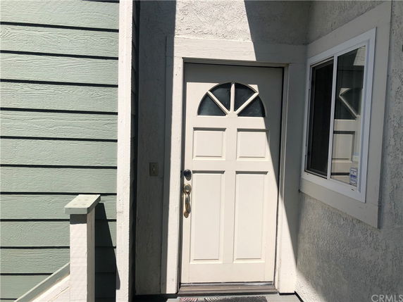 Front view of a house entrance with a white door and a window.