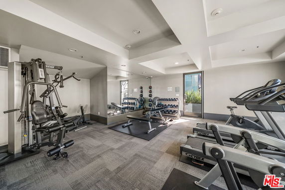 Indoor gym area with exercise equipment and mirrors.