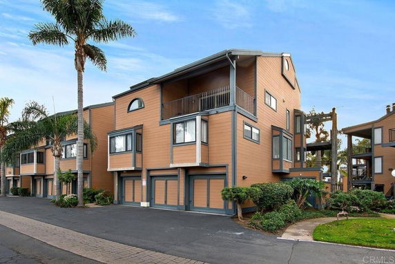 Front view of a multi-story residential building with balconies and garages.