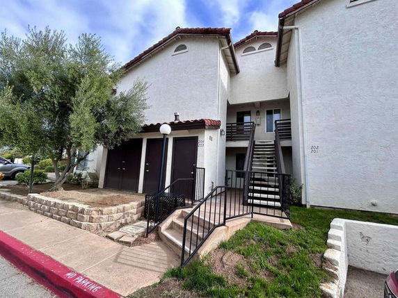 Front view of a residential building with a central staircase leading to upstairs units.