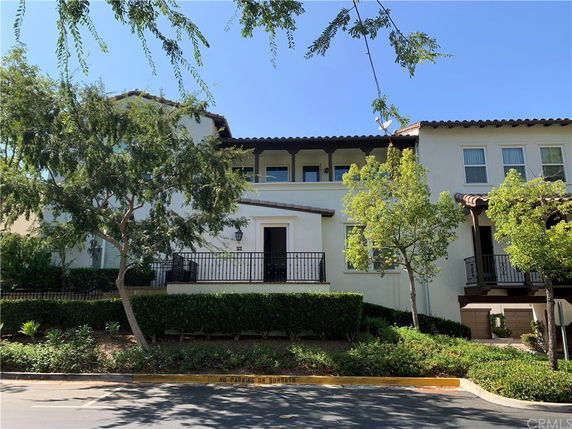 Front view of a multi-story house with a balcony and garage.