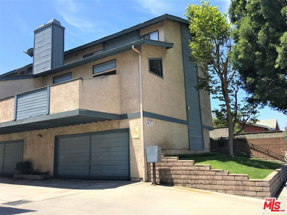 Front view of a multi-story house with a double garage and slanted roof.
