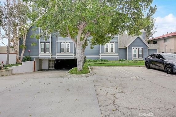 Front view of a two-story house with a gray exterior and parking area.