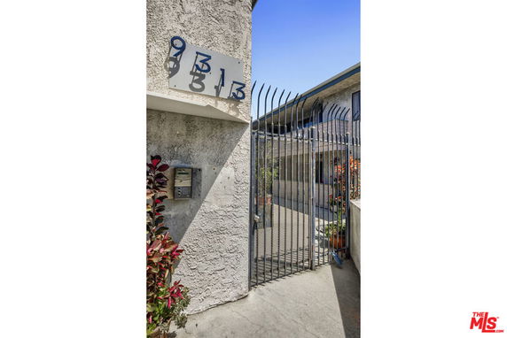 Front view of a building with a gated entrance and visible unit numbers.