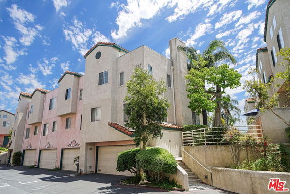 Front view of a multi-story residential building with multiple garage doors.