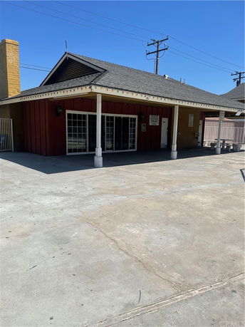 Front view of a single-story building with a sloped roof and a covered porch.