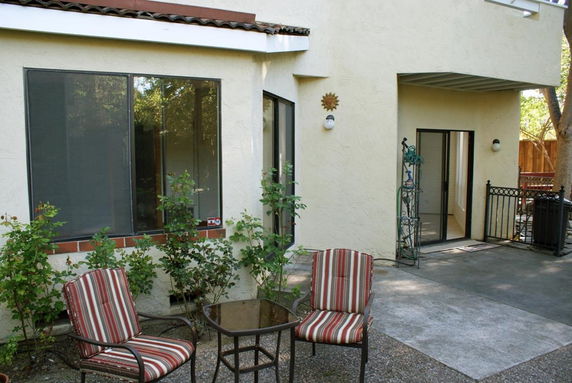 Front view of a house with large windows and a patio area.