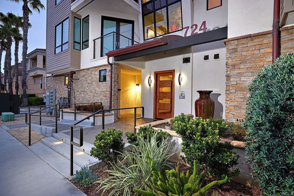 Front view of a modern multi-story building with glass windows and stone accents.