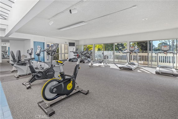 Indoor gym area with exercise bikes, treadmills, and large windows.