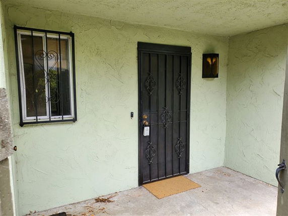 Front view of a house entrance with a metal security door.