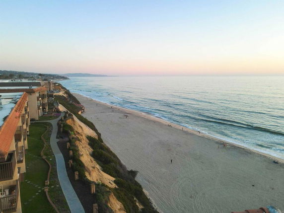 Wide-angle view of a beachfront property with adjacent coastline.