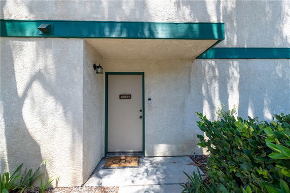 Front entrance of a building with a single door and green trim.