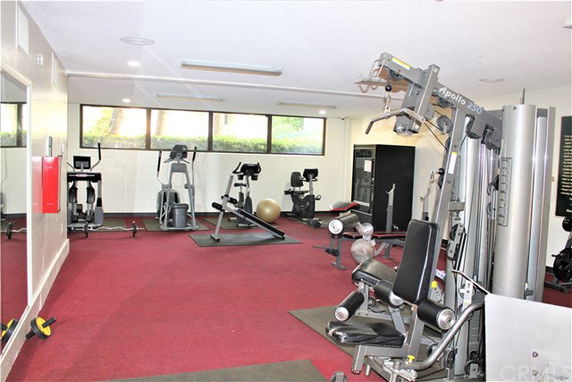 Indoor gym area with various exercise equipment and machines.