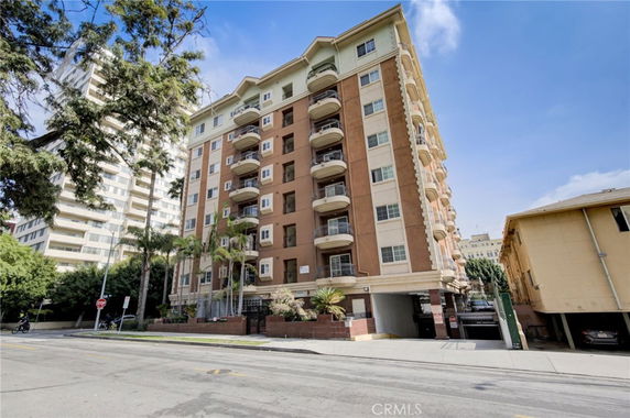 Front view of a multi-story apartment building with balconies.