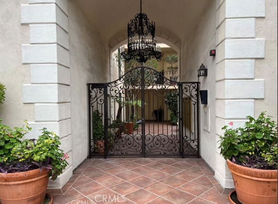 Entrance view of a building with a decorative wrought iron gate and chandelier.