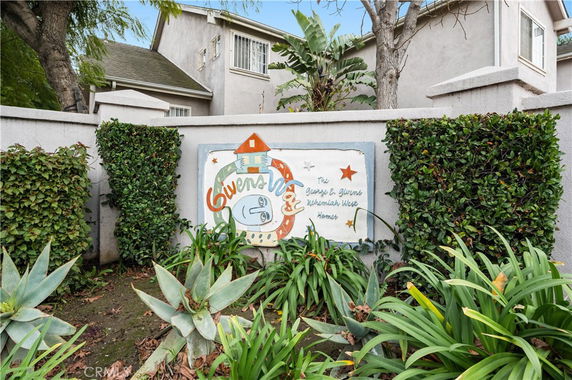 Front view of a residential building with a decorative sign on a wall.