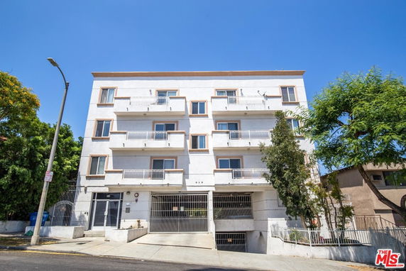 Front view of a multi-story apartment building with balconies.