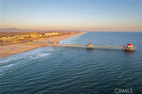 Wide-angle view of a long pier extending into the ocean with a coastline visible in the background.
