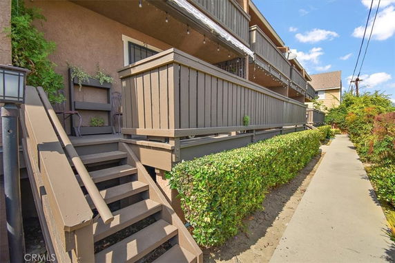 Front view of a multi-story building with wooden railings and stairs.