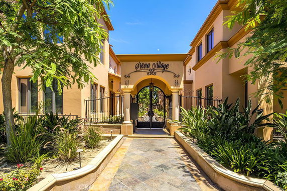 Front view of a two-story building with an arched entrance and decorative wrought iron gate.
