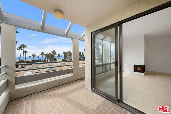 Outdoor balcony with view of ocean and palm trees