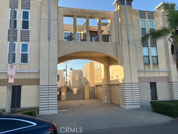 Front view of a multi-story apartment building with an archway entrance.
