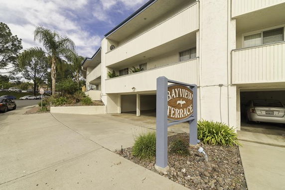 Front view of a multi-story apartment building with a sign labeled 'Bayview Terrace.'