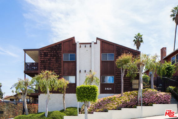 Front view of a multi-story building with a unique roof design and wooden accents.