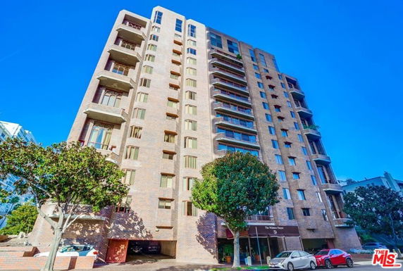 Front view of a multi-story apartment building with balconies.