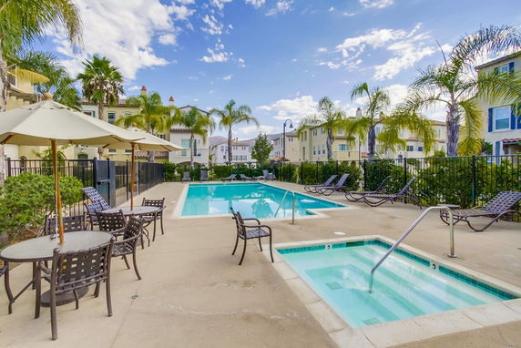 Outdoor swimming pool area with lounge chairs and umbrellas.