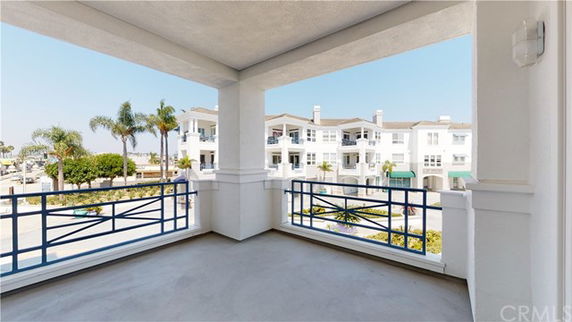 Panoramic view from a building balcony showing nearby residential structures.