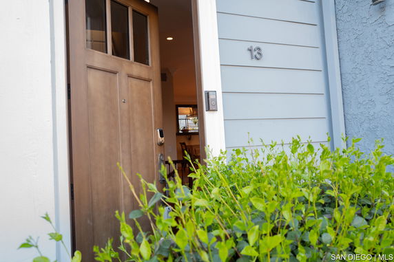 Open front door of a house with number 13 on the exterior wall.
