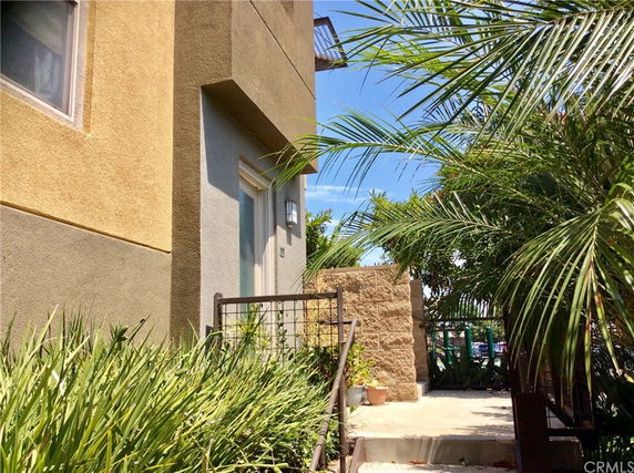 Front view of a house entrance with plants and a pathway.