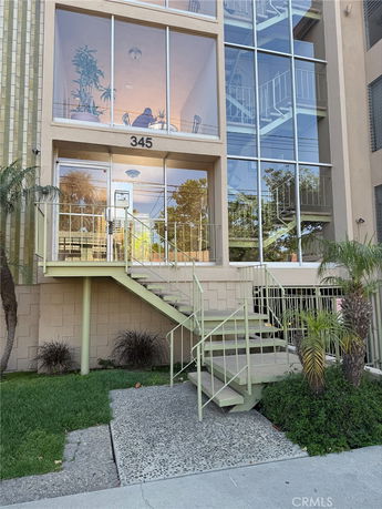 Front view of a building with large windows and external staircase.