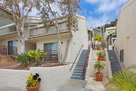 Front view of a multi-level residential building with exterior stairs.