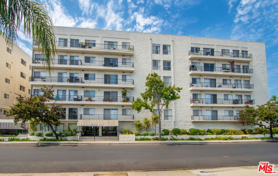 Front view of a multi-story residential building with balconies.