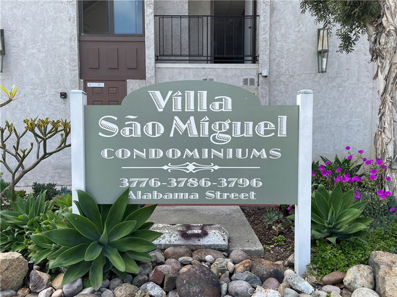Front view of a condominium building with a sign reading 'Villa São Miguel Condominiums'.