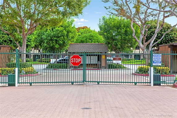 Gated entrance to a residential area with surrounding greenery.