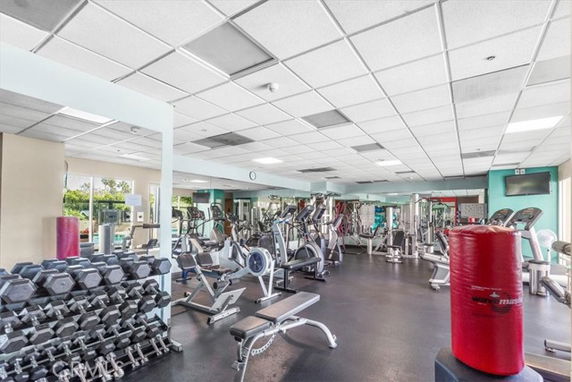 Interior view of a gym with various exercise equipment including treadmills, stationary bikes, and weight racks.