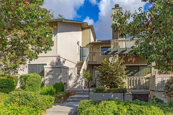 Front view of a residential building with multiple levels and exterior stairs.