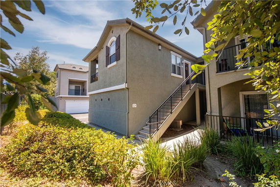 Front view of a multi-level house with outdoor stairs and balcony.